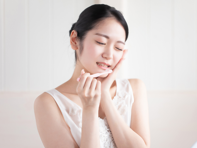 頬を抑える女性